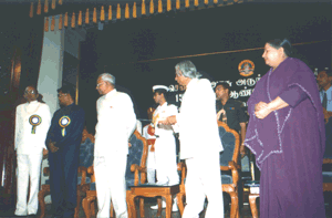 His Excellency, the President of India presses the button to unveil the Comme- morative Plaque - the other dignitaries look on 